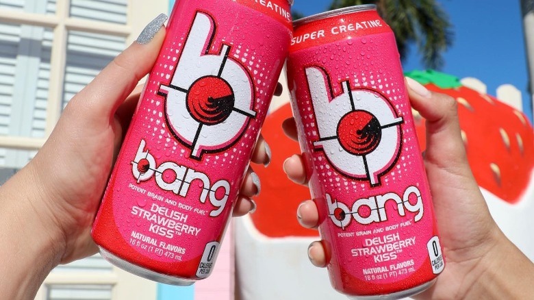 People holding cans of Bang Energy Delish Strawberry Kiss flavor