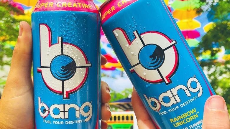 Two cans of Bang Energy Rainbow Unicorn flavor outdoors