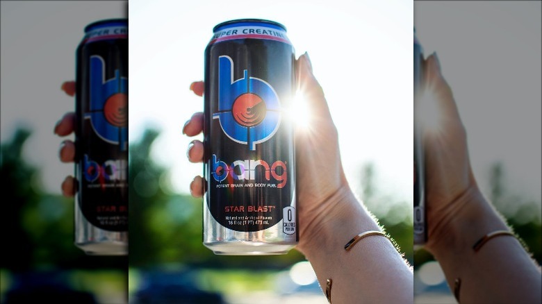 Someone holding a can of Bang Energy Star Blast outdoors