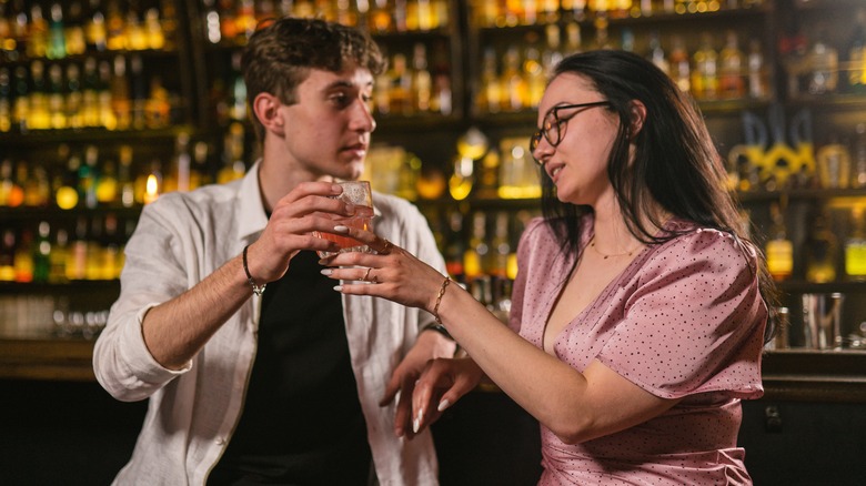 guy offering girl a cocktail