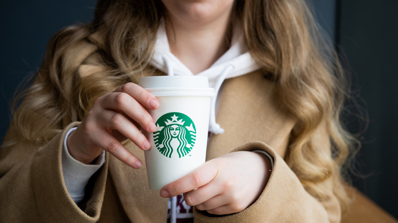 Person holding Starbucks cup