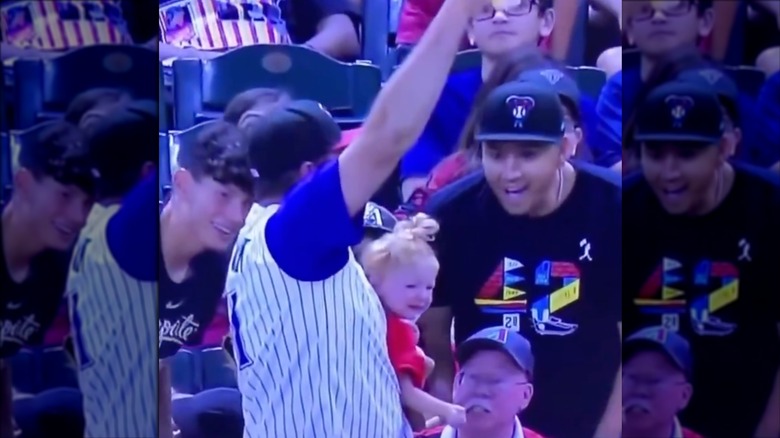 Diamondbacks fan holding beer and baby