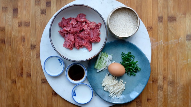 raw beef, egg, scallions, ingredients in bowls