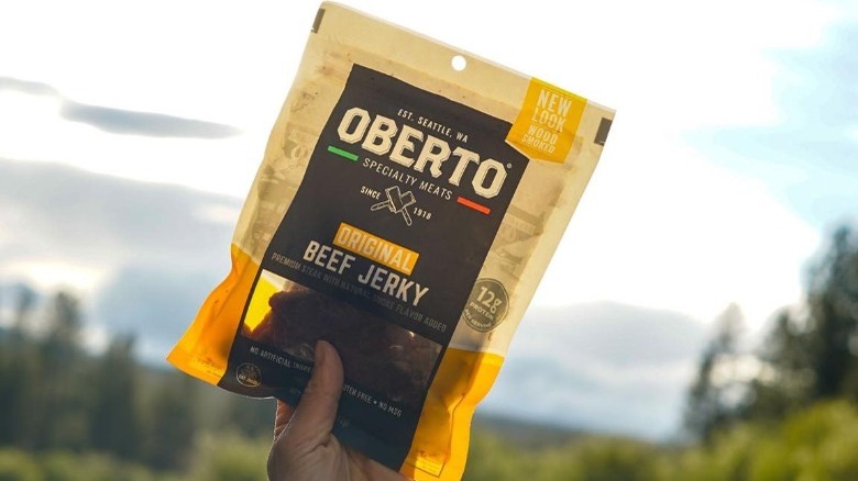 Person holding Oberto Beef Jerky in the air