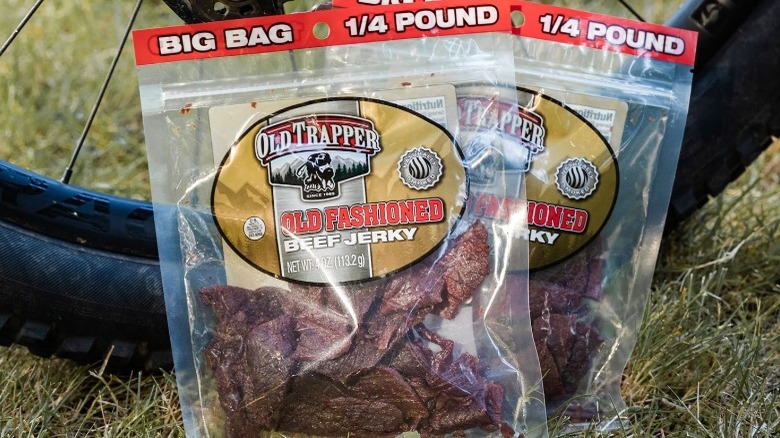 Two packages of Old Trapper Old Fashioned Beef Jerky in front of bike