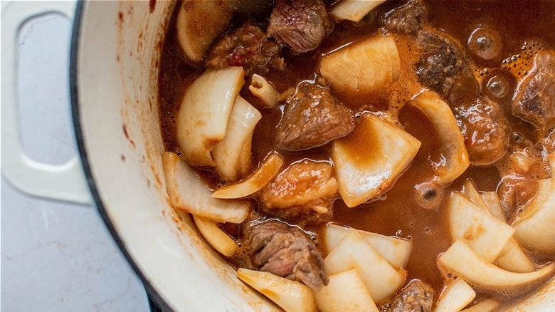 onions and beef simmering in beer