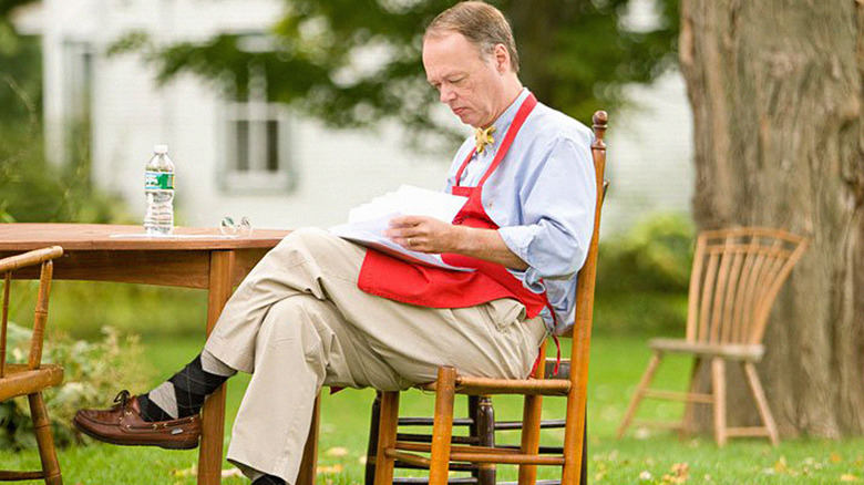 Christopher Kimball sitting outdoors reading