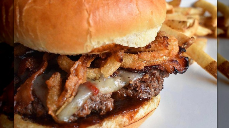 Close-up of a burger with barbecue sauce and fried onions