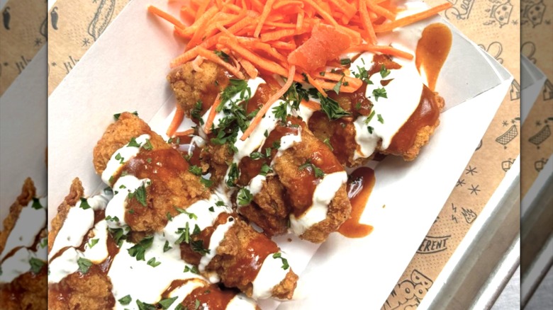 Chicken tenders with sauce and carrot garnish