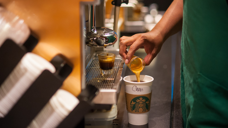 starbucks worker making coffee