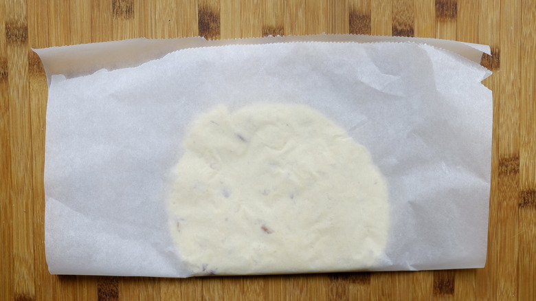 almond crumble flattened between parchment paper