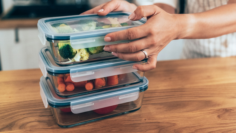 Person stacking glass food containers