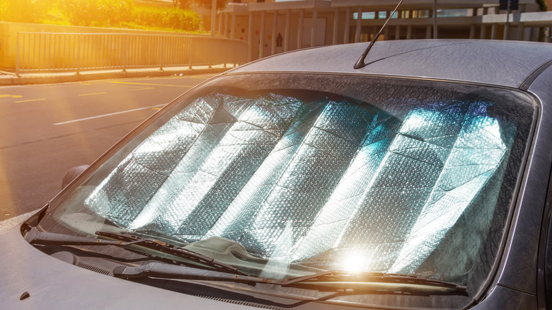 car with reflective windshield protector