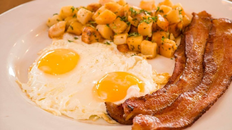 bacon potatoes and eggs on white plate
