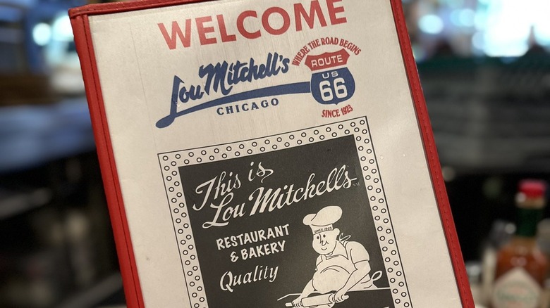 person holding Lou Mitchell's menu