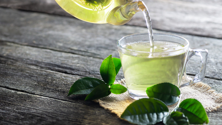 green tea pouring into a mug 