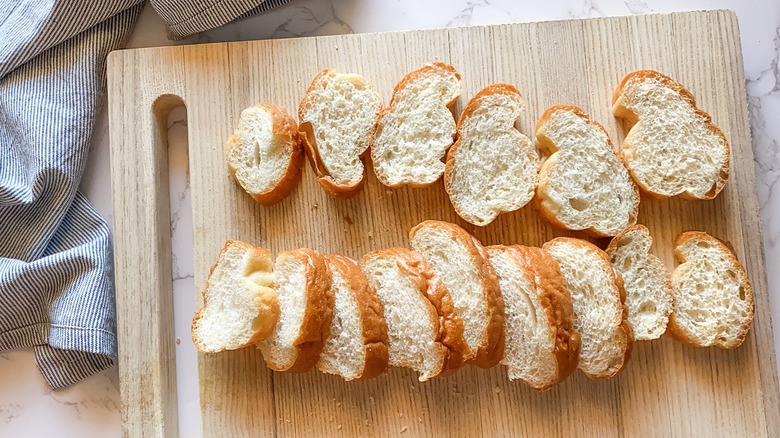 Sliced French bread on wooden cutting board