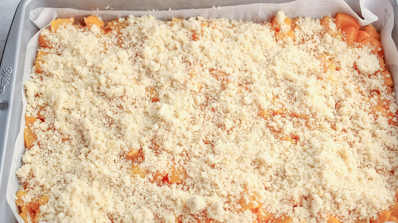 dough crumbled over peaches