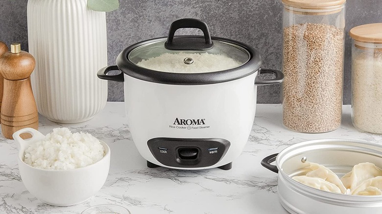 A white aroma rice cooker on a marble countertop