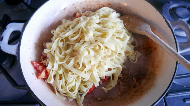 adding pasta to tuna skillet