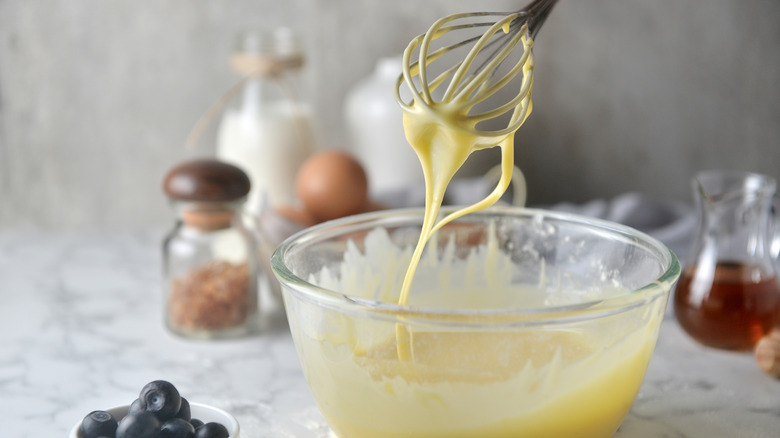 whisk being lifted out of bowl of pancake batter