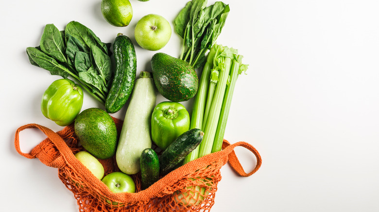 Green vegetables falling out of an orange bag