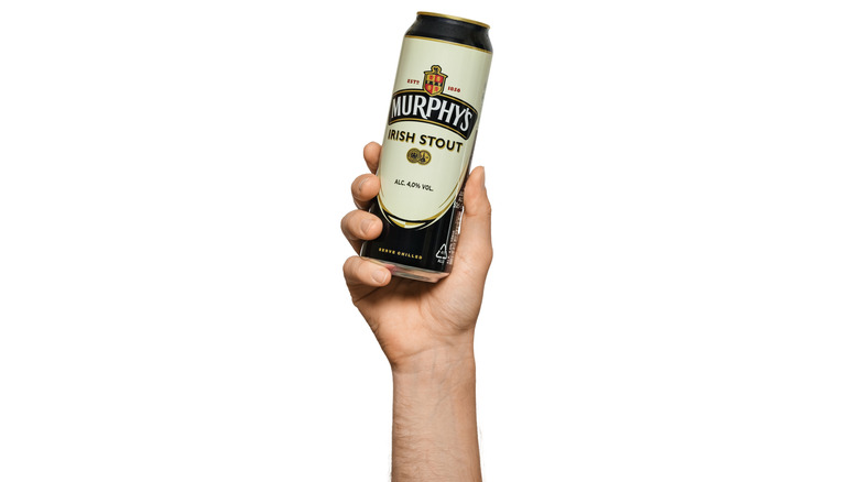 Hand holding Murphy's Irish Stout can