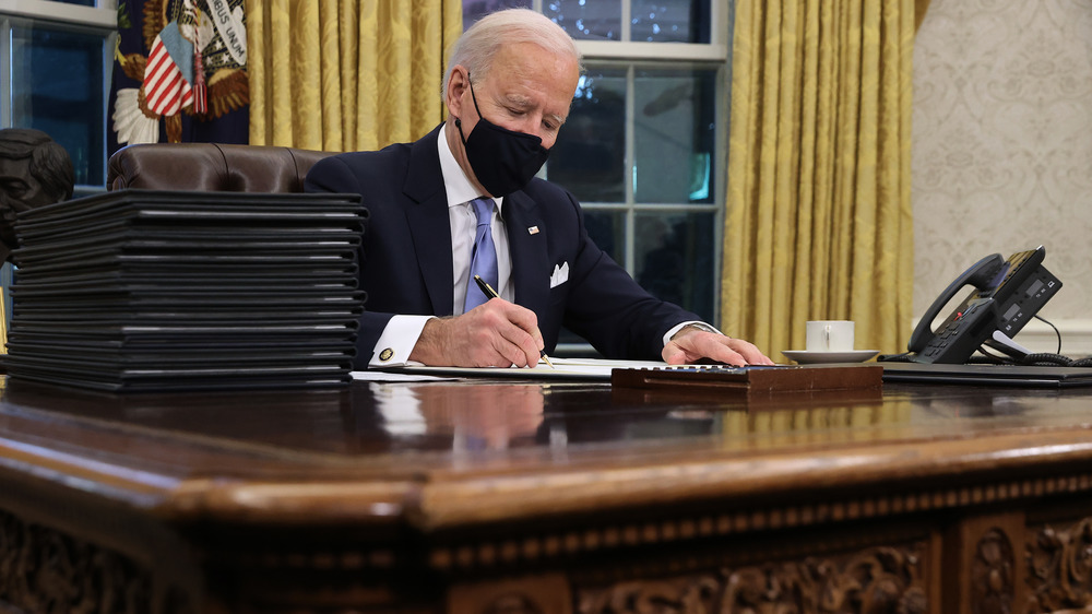 Joe Biden seated at Resolute Desk