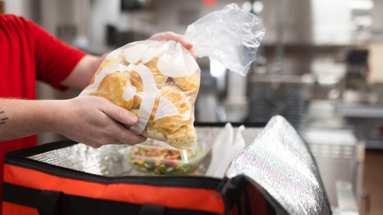 Chick-fil-A employee placing bag of biscuits in cooler bag