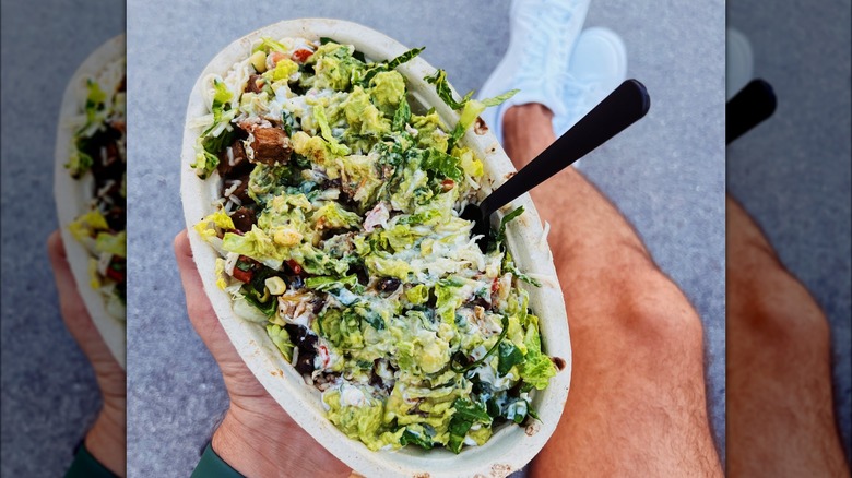 Hand holding a bowl from Chipotle