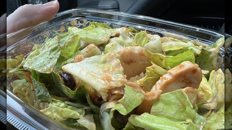 Hands holding a salad from Panera