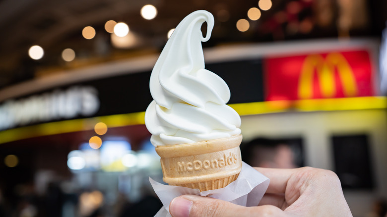 A hand holding a McDonald's soft-serve cone