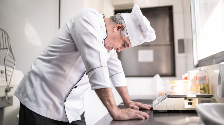 Sad male baker leaning on counter