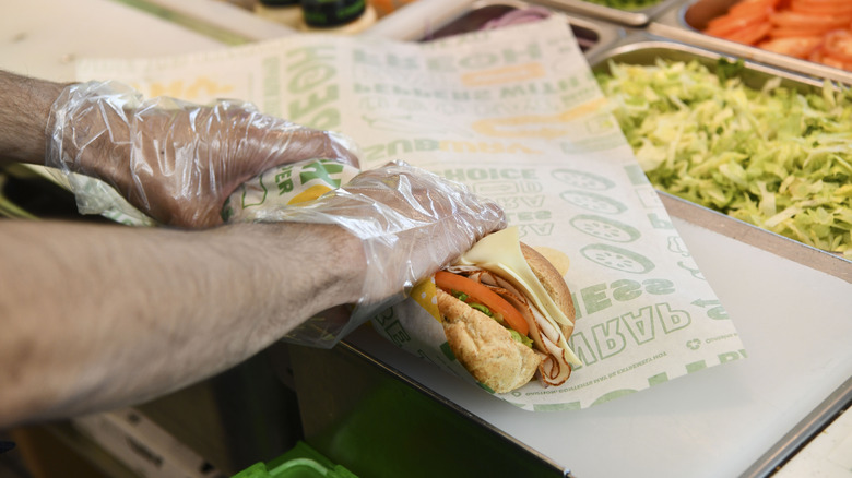 Subway employee wrapping sub