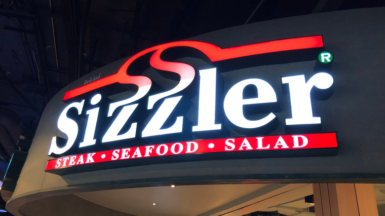 Sizzler sign featured at night