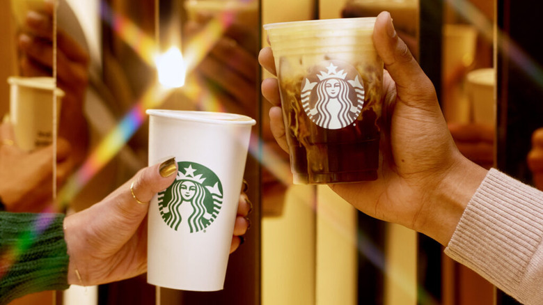 Hands holding Oleato drinks in Starbucks cups