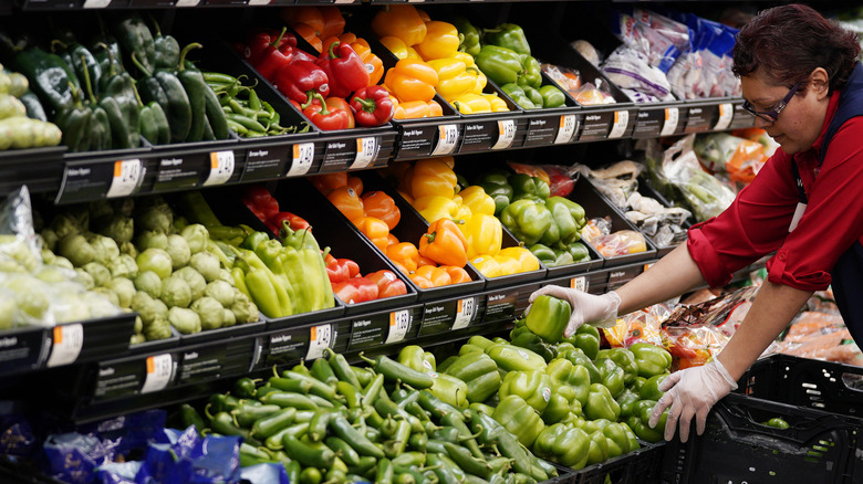 Employee stocks grocery store produce section