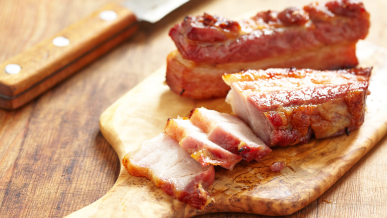 sliced pork belly on cutting board