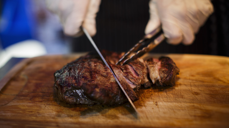 cutting steak on cutting board