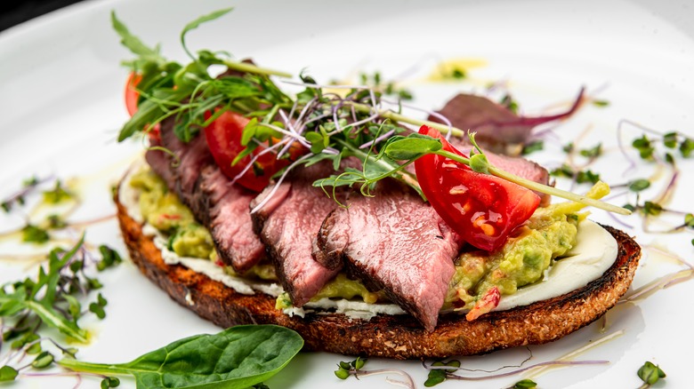 steak with guacamole and microgreens