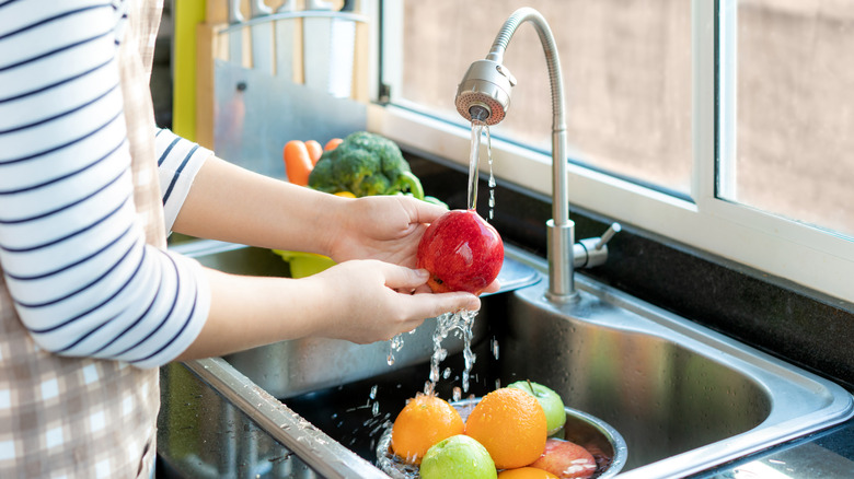 washing fruit under faucet 