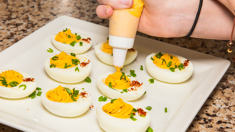 person filling deviled eggs