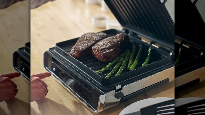Cooked steaks and asparagus in George Foreman Grill