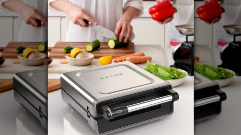 Man chopping veggies behind George Foreman Grill