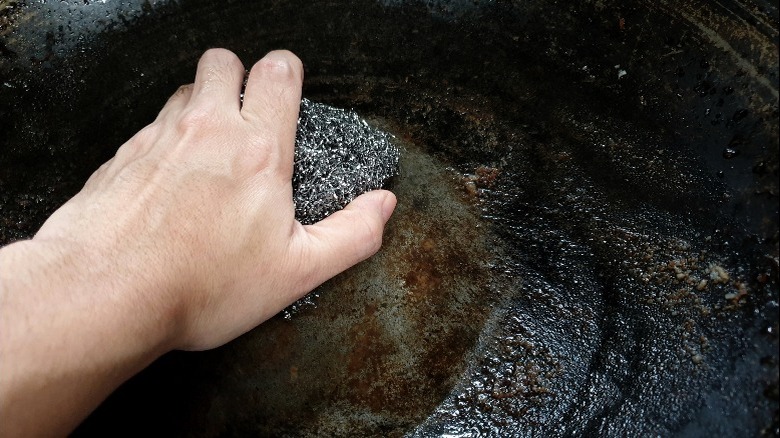 Hand scrubbing pan with steel wool