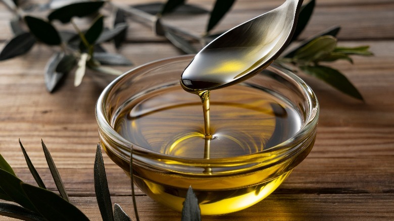Spoon over bowl of olive oil
