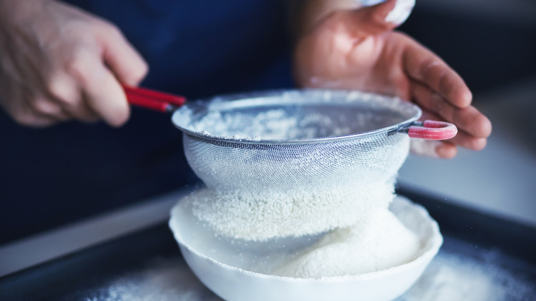 man sifting flour with strainer