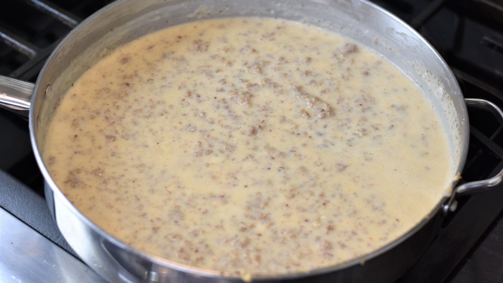 making sausage gravy in a steel pan