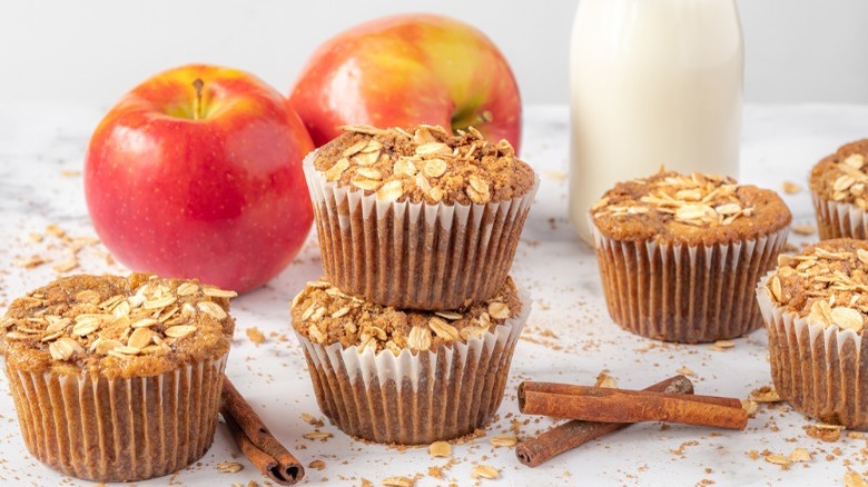 Apple cinnamon muffins pictured with apples and milk