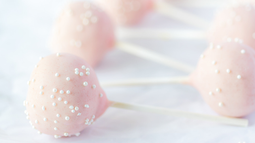 cake pops coated in pink chocolate with white sprinkles 